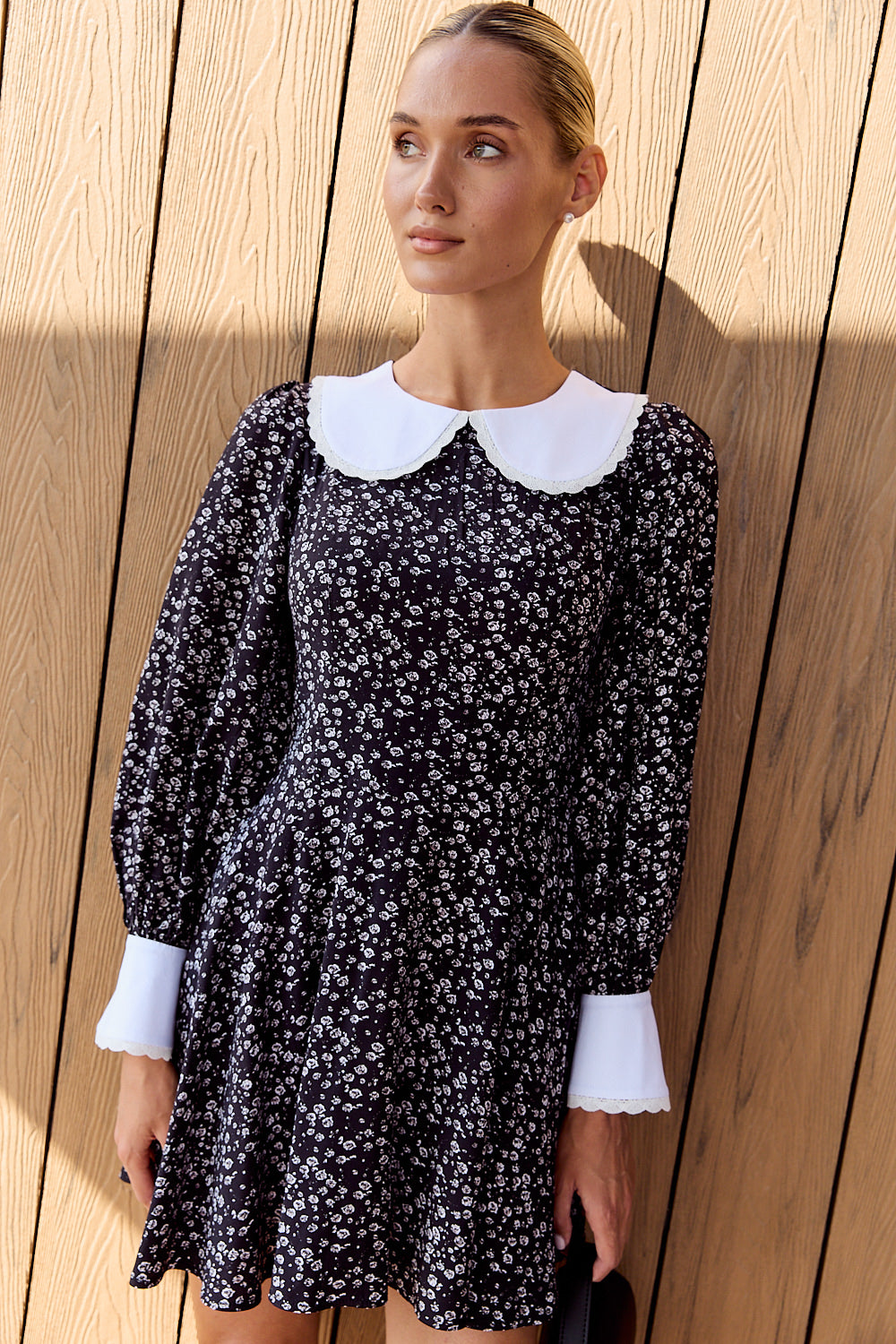 Black semi-fitted dress with a half-sun skirt and puffy cuffed sleeves