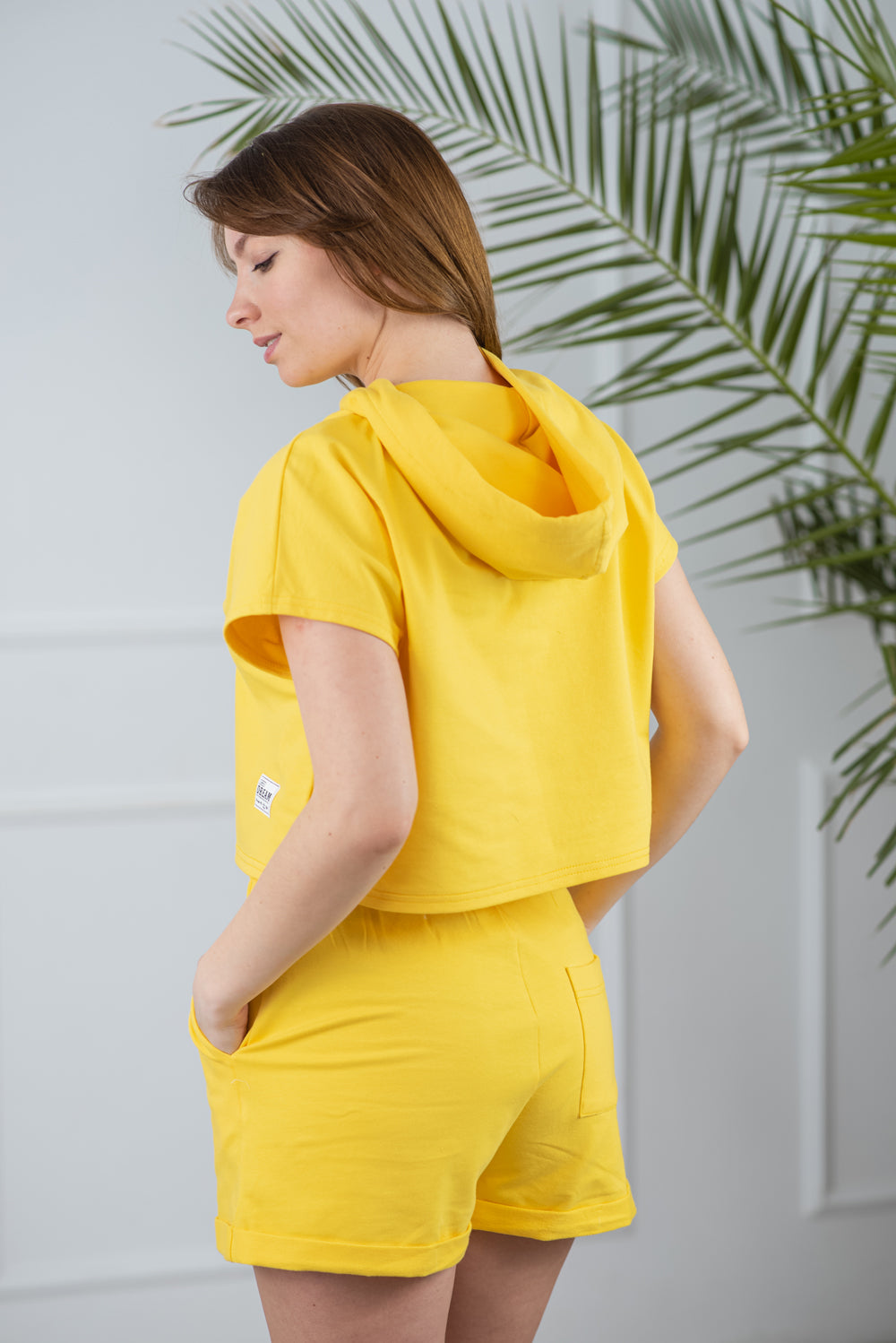 Traje de color amarillo brillante pantalones cortos y sudadera con capucha.