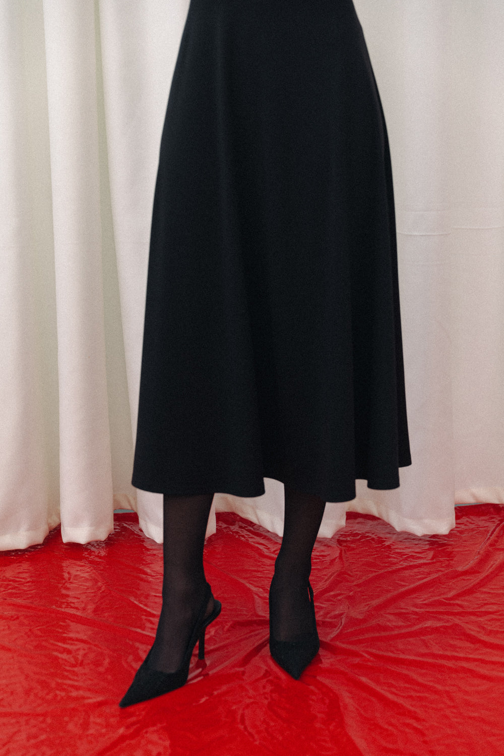 Black fitted midi dress with sophisticated flared skirt