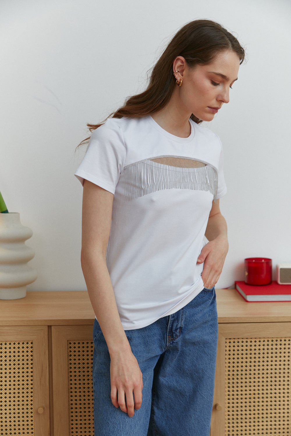 Camiseta blanca con el pecho recortado decorado con cuentas de plata con flecos