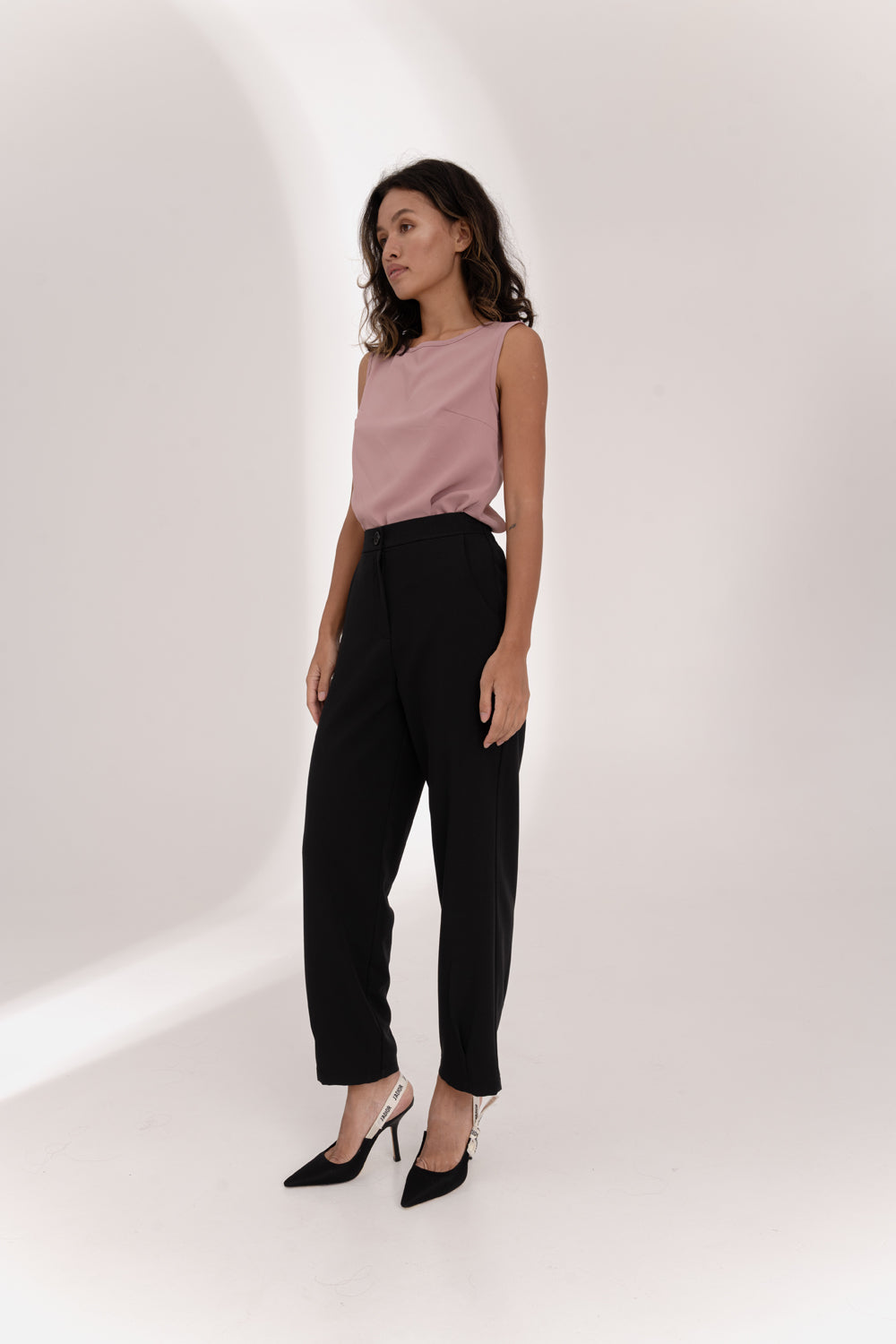 Black trousers with an elasticated waistband and pleats at the hem