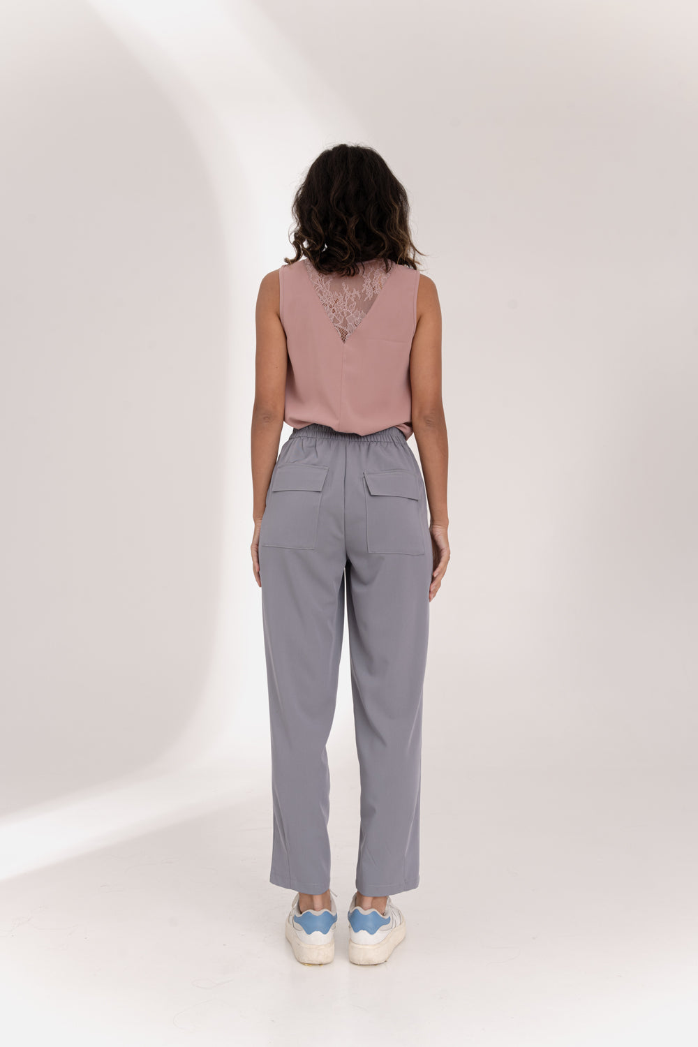 Gray trousers with an elasticated waistband and pleats at the hem