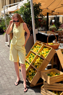 Geel damespak met vest en lange shorts.