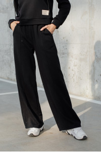 Szerokie czarne spodnie sportowe z podszewką polarową i kantami . Czarny. Черный